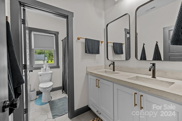 bathroom featuring visible vents, a sink, toilet, and double vanity