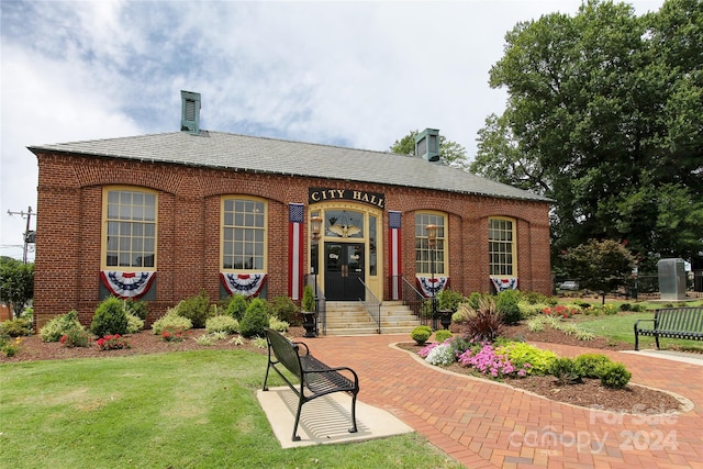 view of front of property with a front yard and brick siding