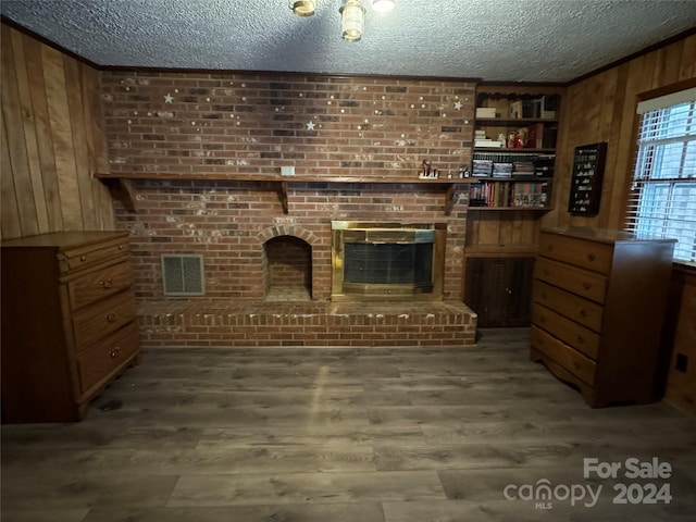 4539 S New Hope Rd, Gastonia, NC 28056 - living room with visible vents, wood finished floors, a textured ceiling, and wood walls