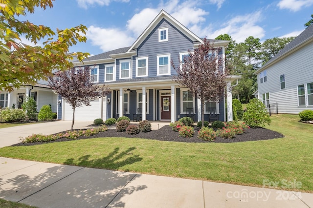 view of front of home with a front yard, a garage, and covered porch