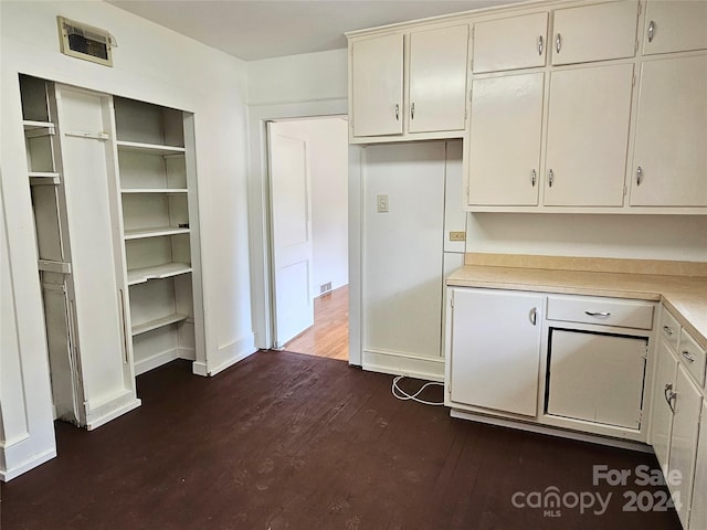 kitchen with dark wood-type flooring and white cabinetry