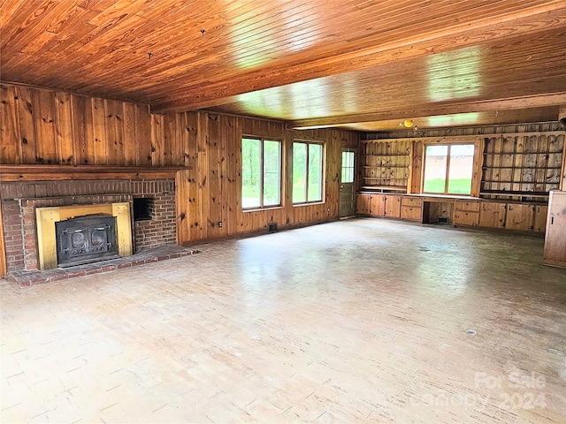 unfurnished living room with wood walls and a brick fireplace