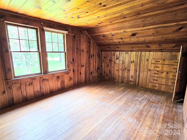 additional living space featuring wood walls, vaulted ceiling, hardwood / wood-style flooring, and wood ceiling