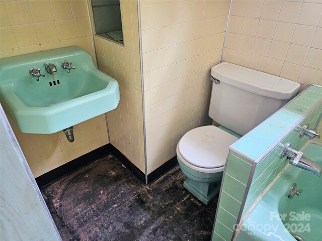 bathroom featuring sink, toilet, and tile walls