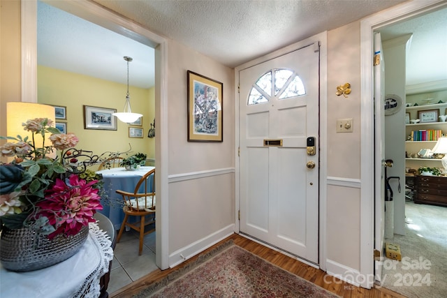 entryway featuring wood-type flooring and a textured ceiling