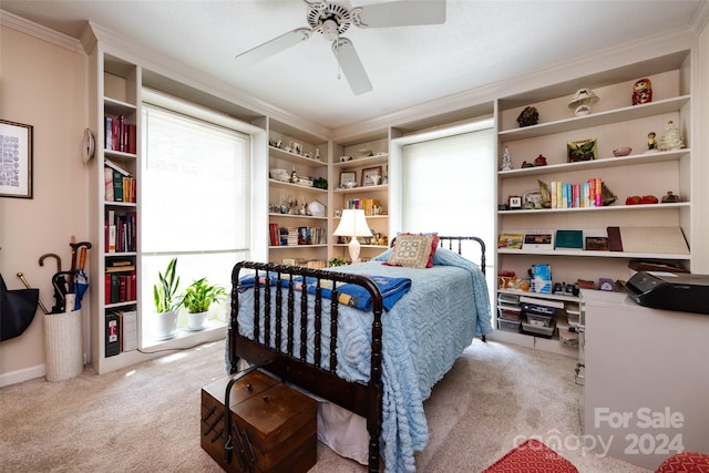 bedroom with ornamental molding, light colored carpet, and ceiling fan