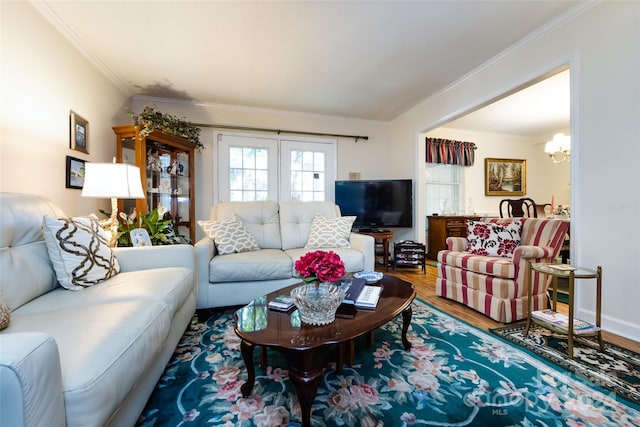 living room with crown molding, hardwood / wood-style floors, and a chandelier