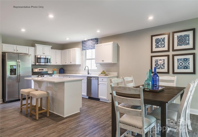 kitchen featuring sink, appliances with stainless steel finishes, white cabinets, and a center island