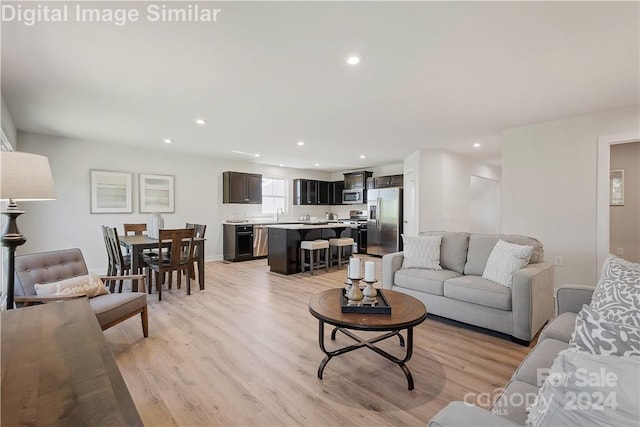 living room with light hardwood / wood-style floors and sink