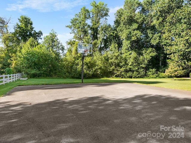 view of sport court with a lawn