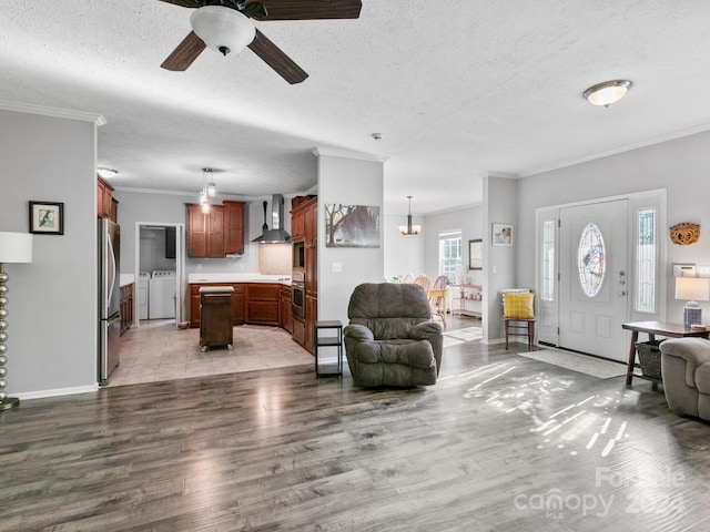 living room with a textured ceiling, ceiling fan, light tile patterned flooring, and separate washer and dryer