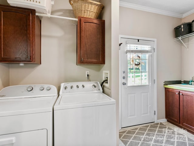 washroom featuring sink, ornamental molding, independent washer and dryer, and cabinets