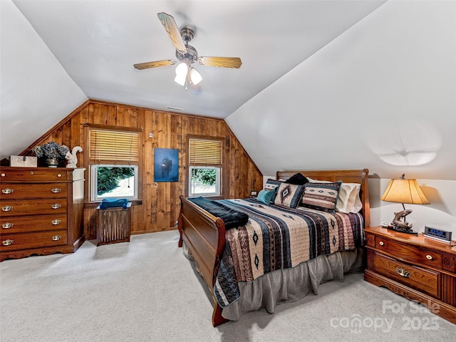 carpeted bedroom with a ceiling fan, lofted ceiling, and wood walls