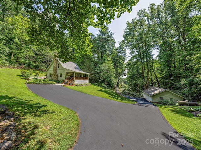 view of front of house with driveway, a porch, and a front yard