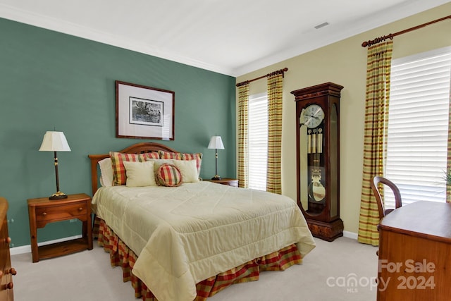 bedroom featuring crown molding and light colored carpet