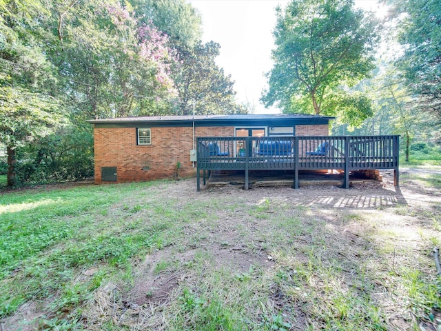 rear view of property with a lawn and a deck