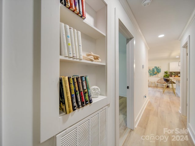 hallway featuring light hardwood / wood-style floors and crown molding