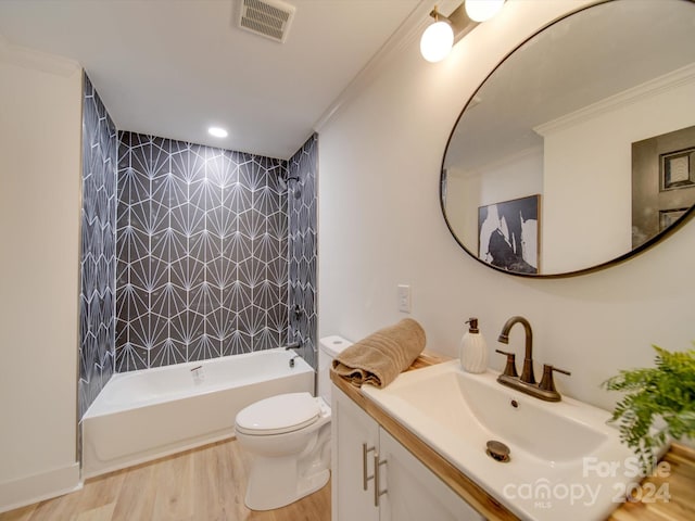 full bathroom featuring ornamental molding, hardwood / wood-style flooring, vanity, shower / bath combination, and toilet