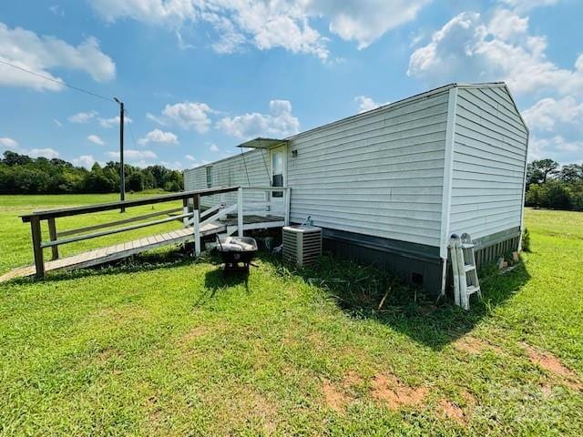 view of side of property with a yard and central AC