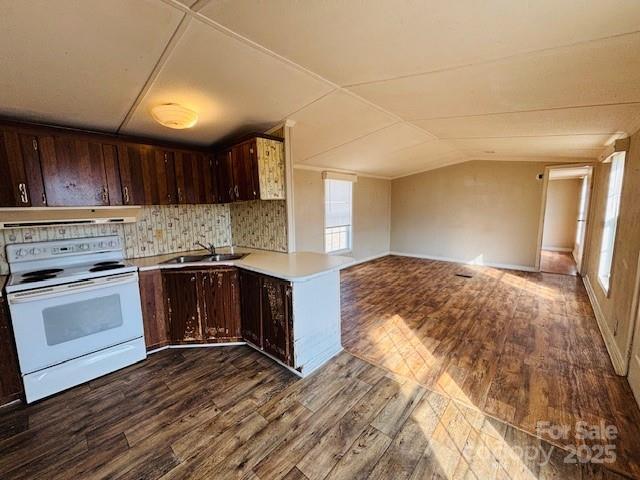 kitchen with dark brown cabinetry, lofted ceiling, white electric range oven, extractor fan, and dark hardwood / wood-style floors