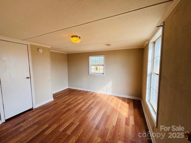 empty room with hardwood / wood-style flooring and a textured ceiling