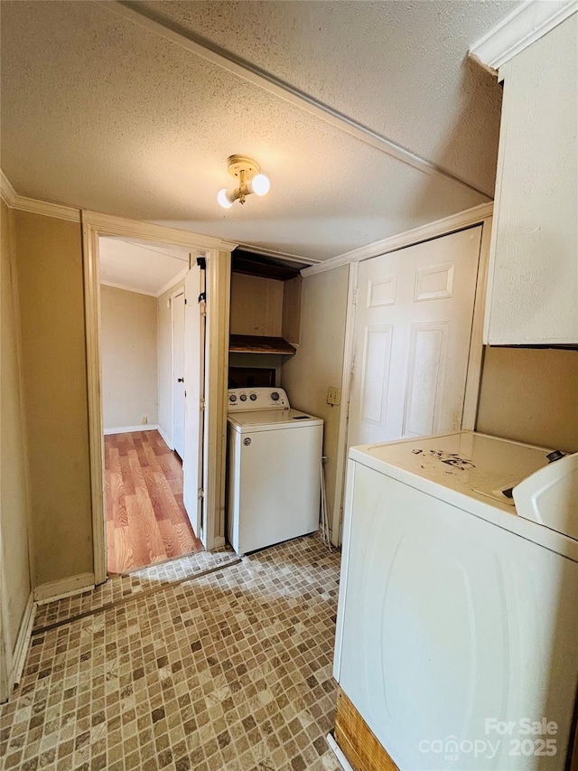 laundry area with washer / clothes dryer, a textured ceiling, and cabinets