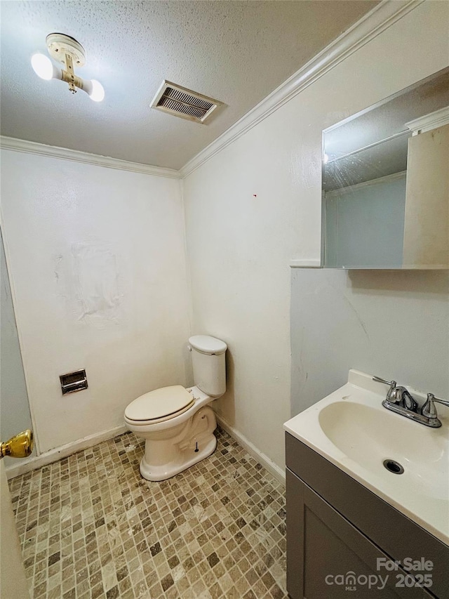 bathroom with ornamental molding, vanity, a textured ceiling, and toilet