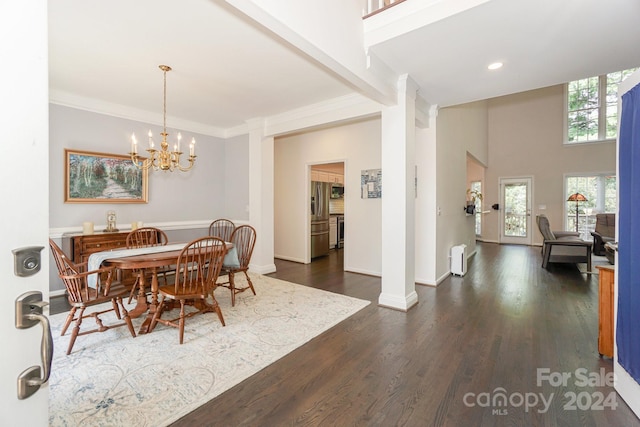 dining room with ornamental molding, an inviting chandelier, and dark hardwood / wood-style flooring