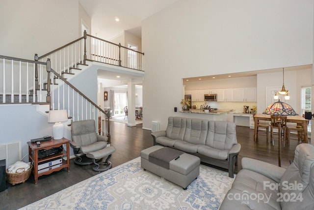 living room featuring a towering ceiling and wood-type flooring