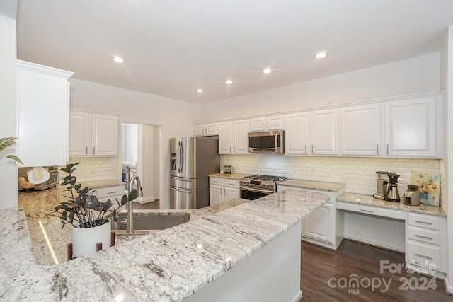 kitchen with light stone counters, white cabinets, stainless steel appliances, and dark hardwood / wood-style floors