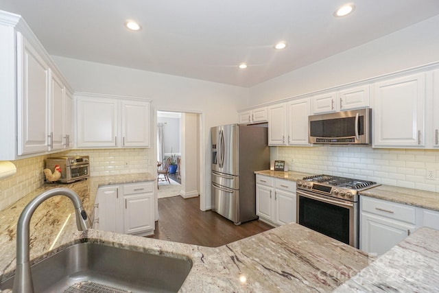 kitchen with dark hardwood / wood-style floors, white cabinetry, sink, and stainless steel appliances