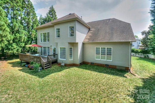 back of property with a yard and a wooden deck