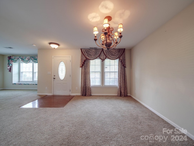 entryway featuring carpet floors and an inviting chandelier