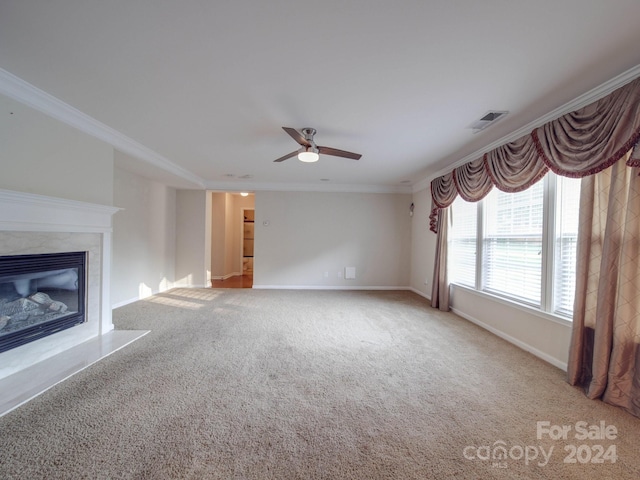 unfurnished living room featuring a fireplace, carpet flooring, ceiling fan, and ornamental molding