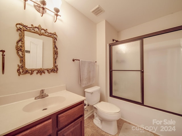 full bathroom with tile patterned flooring, toilet, vanity, and bath / shower combo with glass door