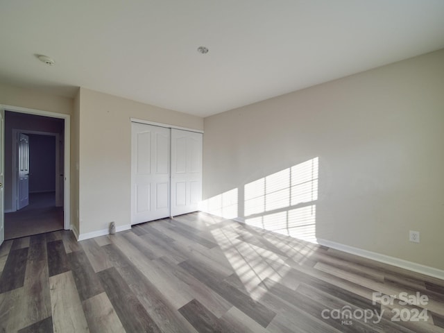 unfurnished bedroom with a closet and hardwood / wood-style flooring