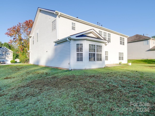 back of house featuring a lawn