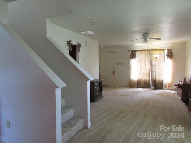 carpeted entryway featuring ceiling fan