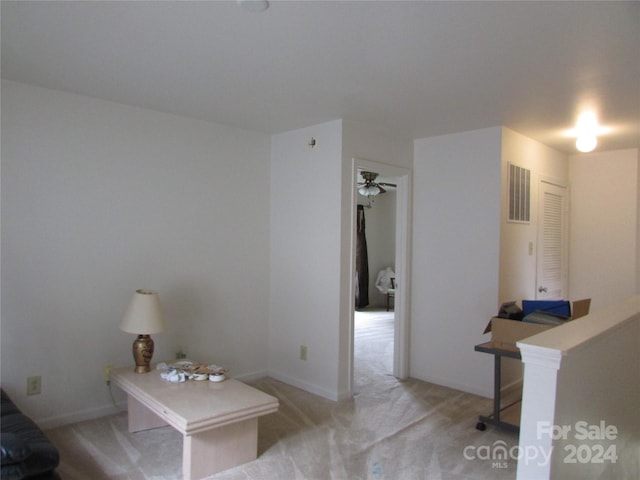 interior space with ceiling fan and light colored carpet