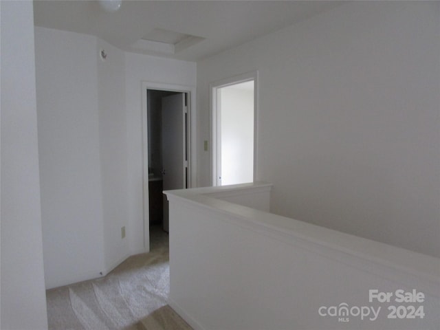 hallway featuring light colored carpet