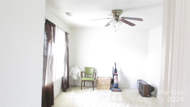 sitting room featuring light carpet and ceiling fan