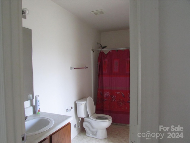 bathroom with a shower with shower curtain, tile patterned flooring, vanity, and toilet