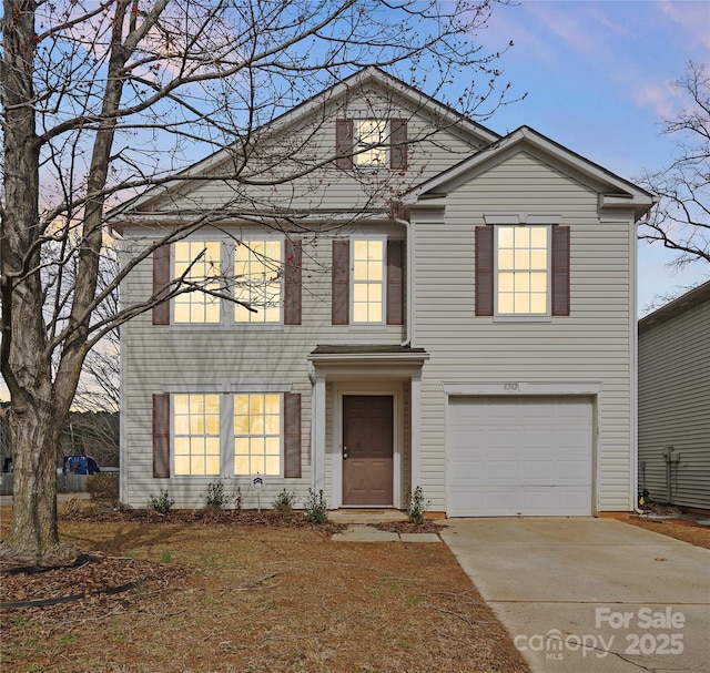 traditional home with concrete driveway and an attached garage