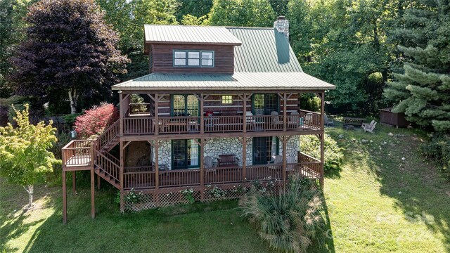 rear view of house with a yard and a wooden deck