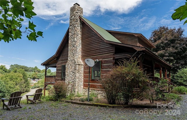 view of property exterior featuring metal roof and a chimney