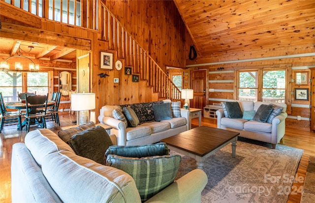 living room with wood walls, a notable chandelier, and a wealth of natural light