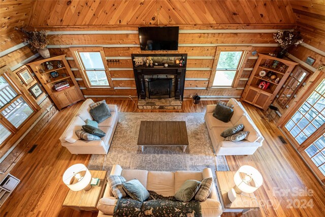 living area featuring wood ceiling, a fireplace, and wood finished floors