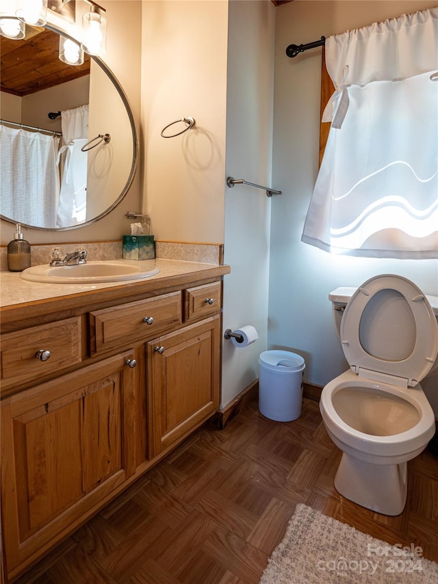 bathroom featuring vanity, toilet, and baseboards