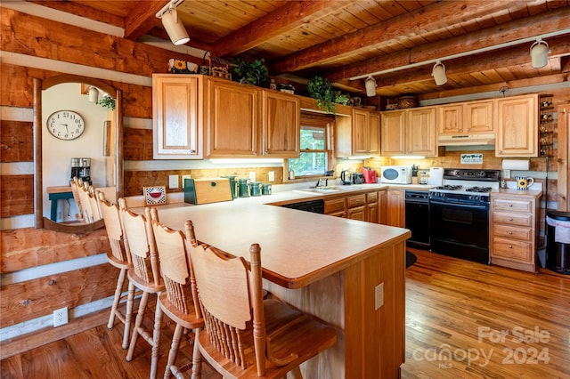 kitchen with wooden ceiling, gas range, white microwave, and light wood finished floors