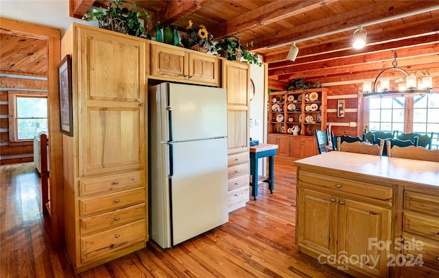 kitchen with wood ceiling, beamed ceiling, freestanding refrigerator, light countertops, and light wood-type flooring